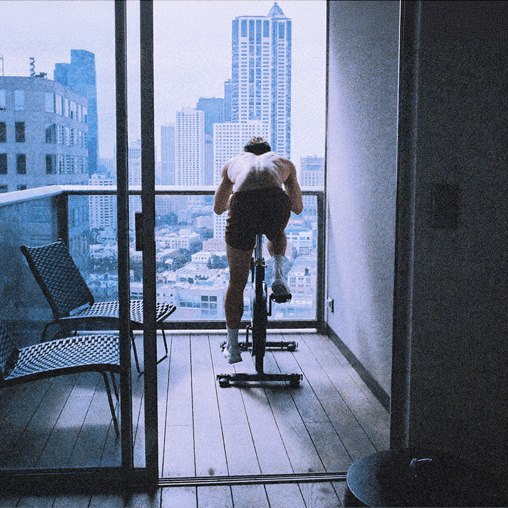 Man training on a bike on a city balcony
