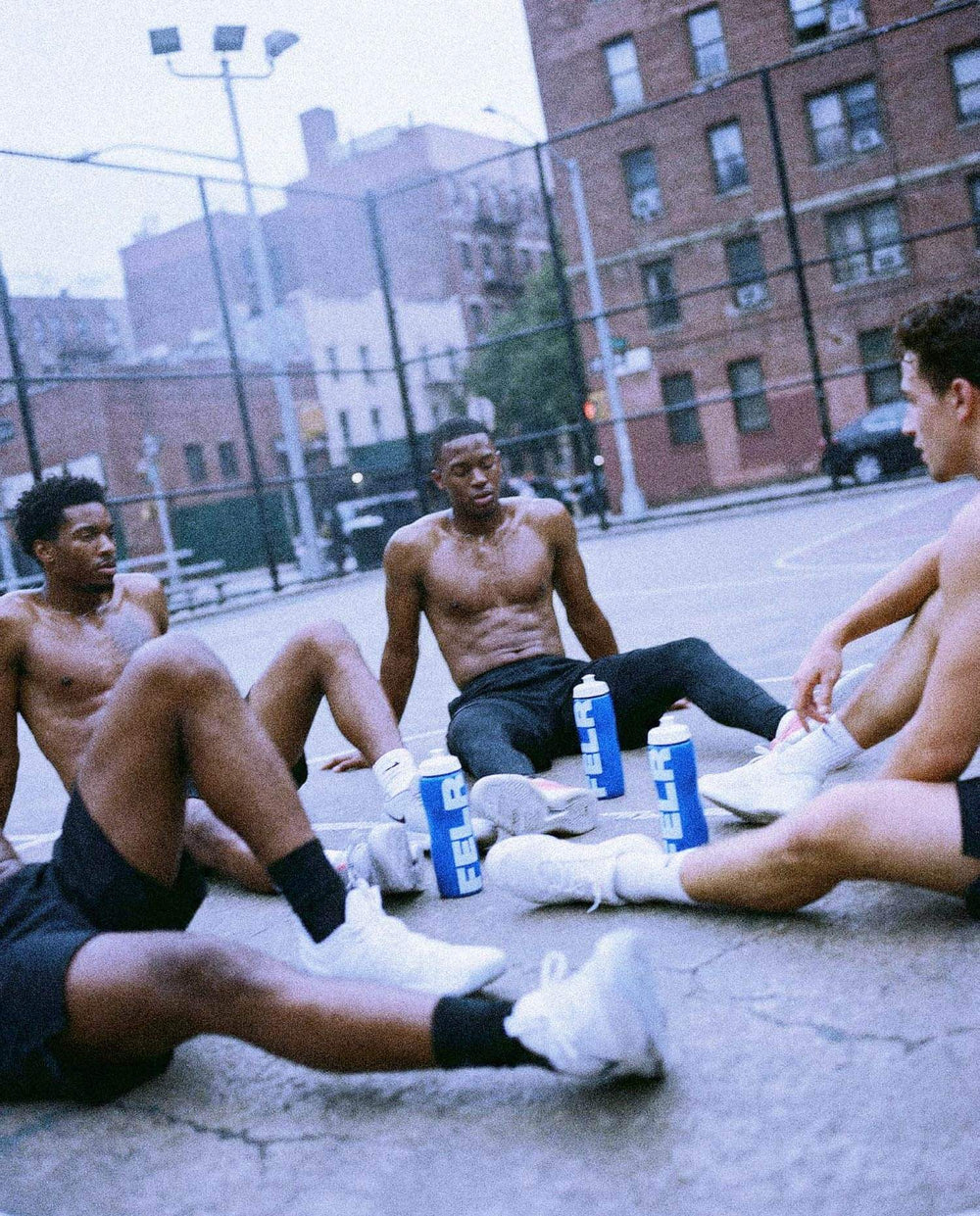 Men resting on a basketball court after training